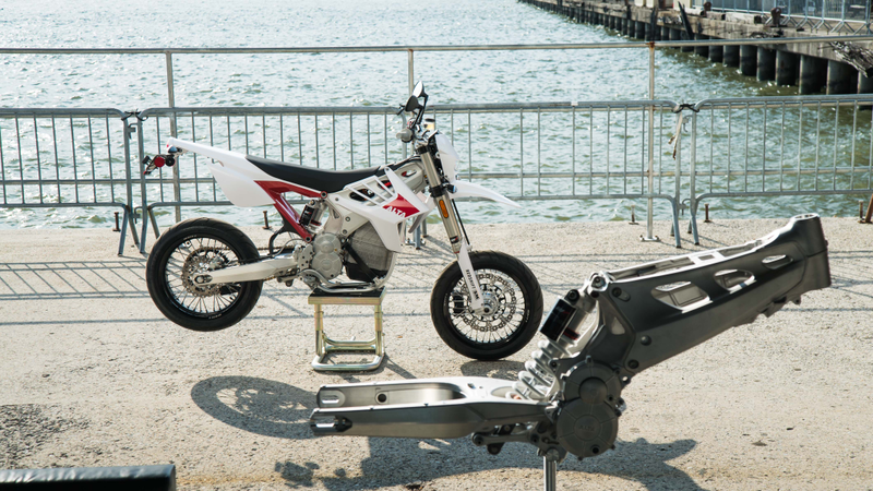 The Redshift SM’s naked frame in the foreground, completed motorcycle in the background.